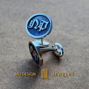 a pair of cufflinks with a logo on them