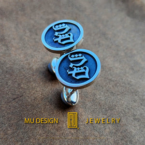 a pair of cufflinks with a design on them